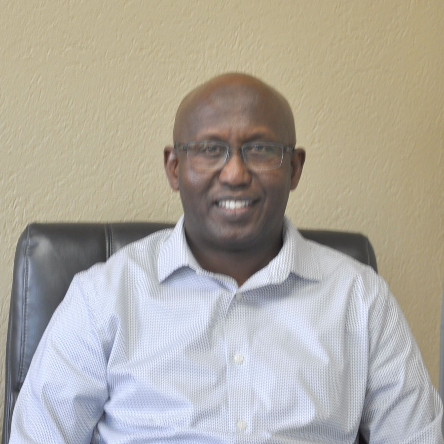 Abdullah Hiadmed smiling at the camera, while sitting in a black leather chair